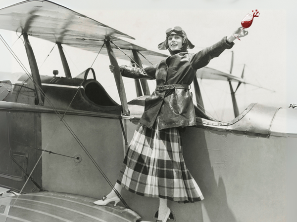 aviatrix on biplane with glass of red wine